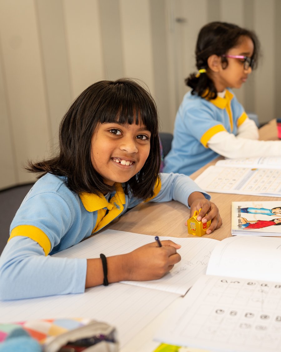 A volunteer helping students with their workbooks at Paramitha Sinhala Language School
