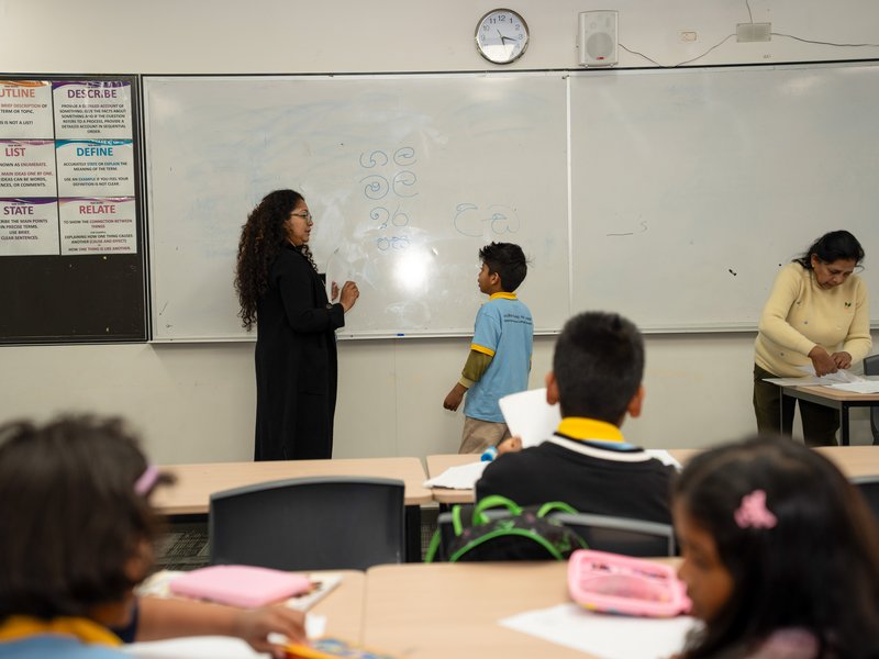 A student practising Sinhala writing at the whiteboard