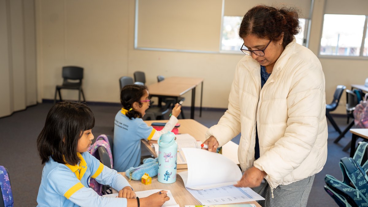 Two students writing together at their desk